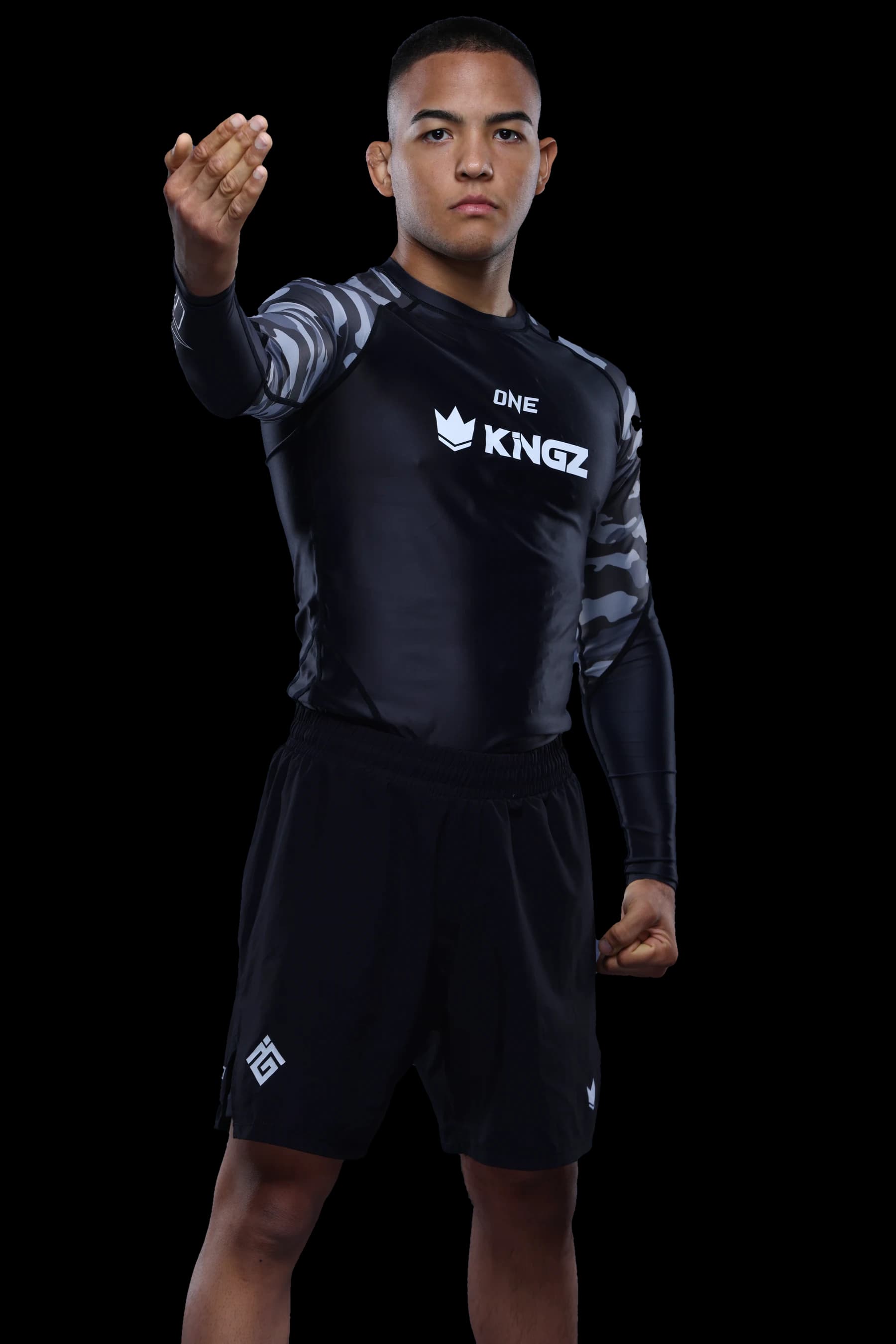 Diogo “Baby Shark” Reis de corpo inteiro, de rashguard, com a mão erguida